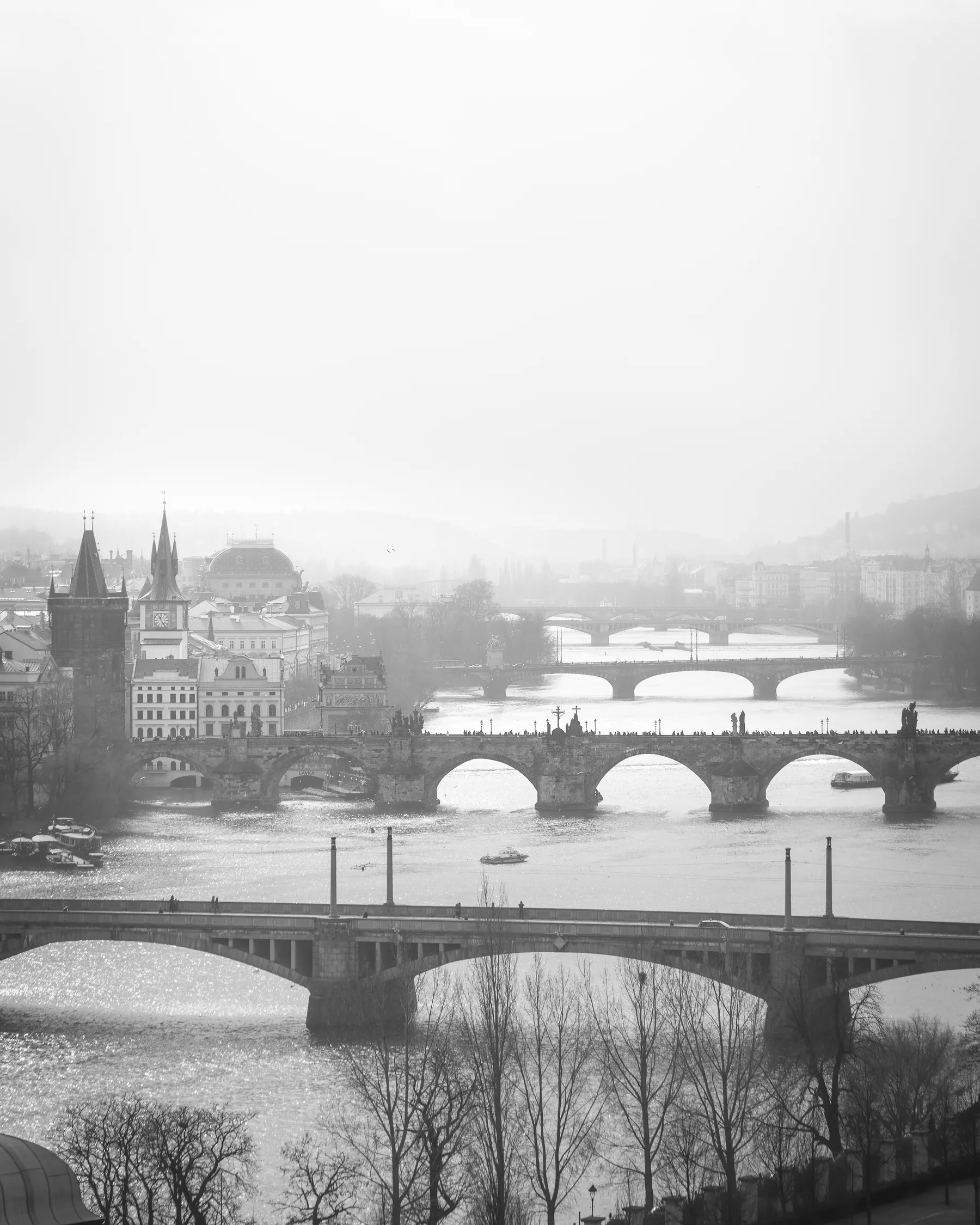 Black and white fine art photo of the bridges of Prague on a misty, foggy morning.